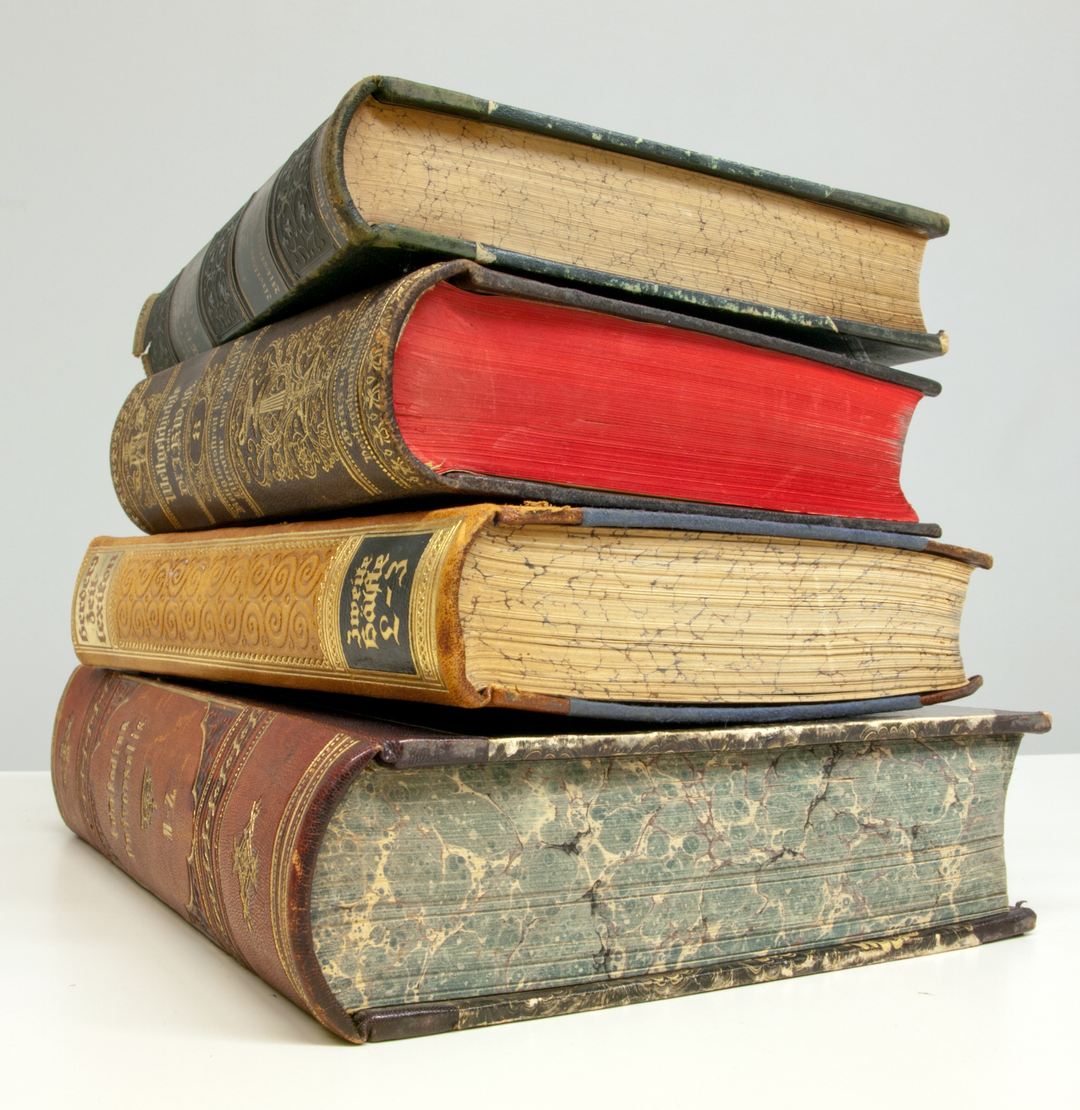 Pila de cuatro libros antiguos encuadernados en piel