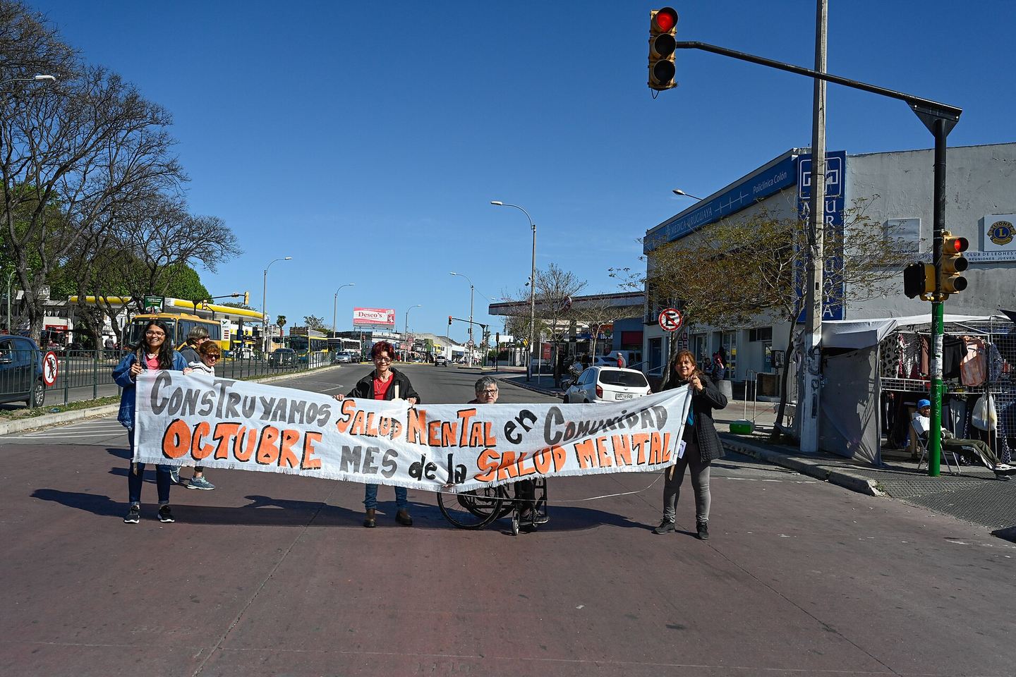 Varias personas sostienen en una calle una pancarta que dice «Construyamos salud mental en comunidad. Octubre, mes de la salud mental»