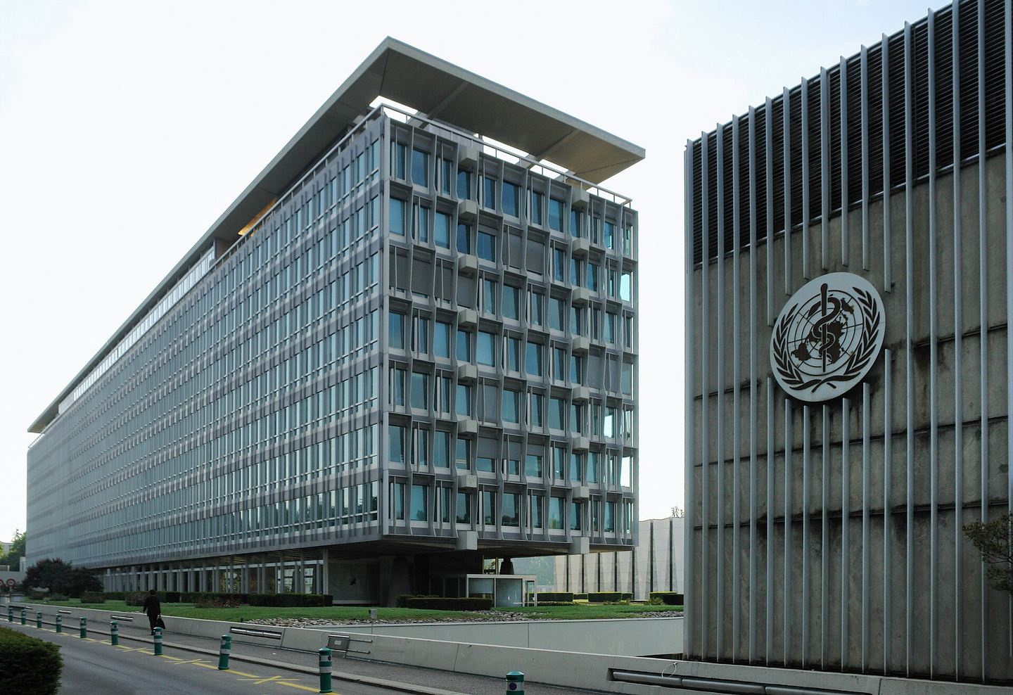 Edificio de la sede de la Organización Mundial de la Salud en Ginebra, con el emblema de la OMS en un muro
